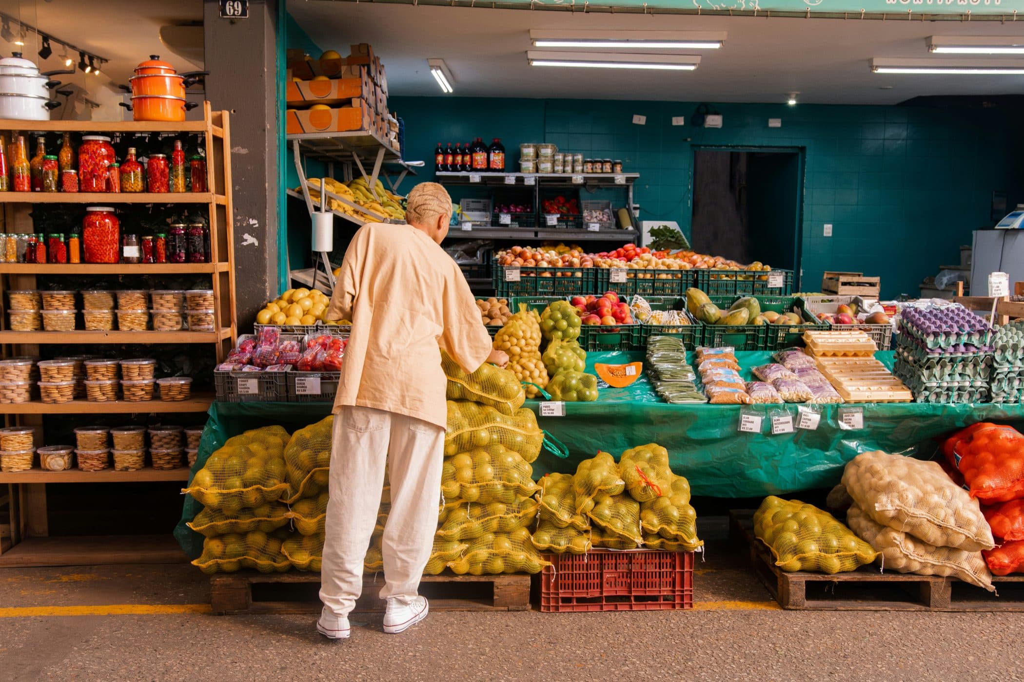 A person is perusing the vegetables at a market booth