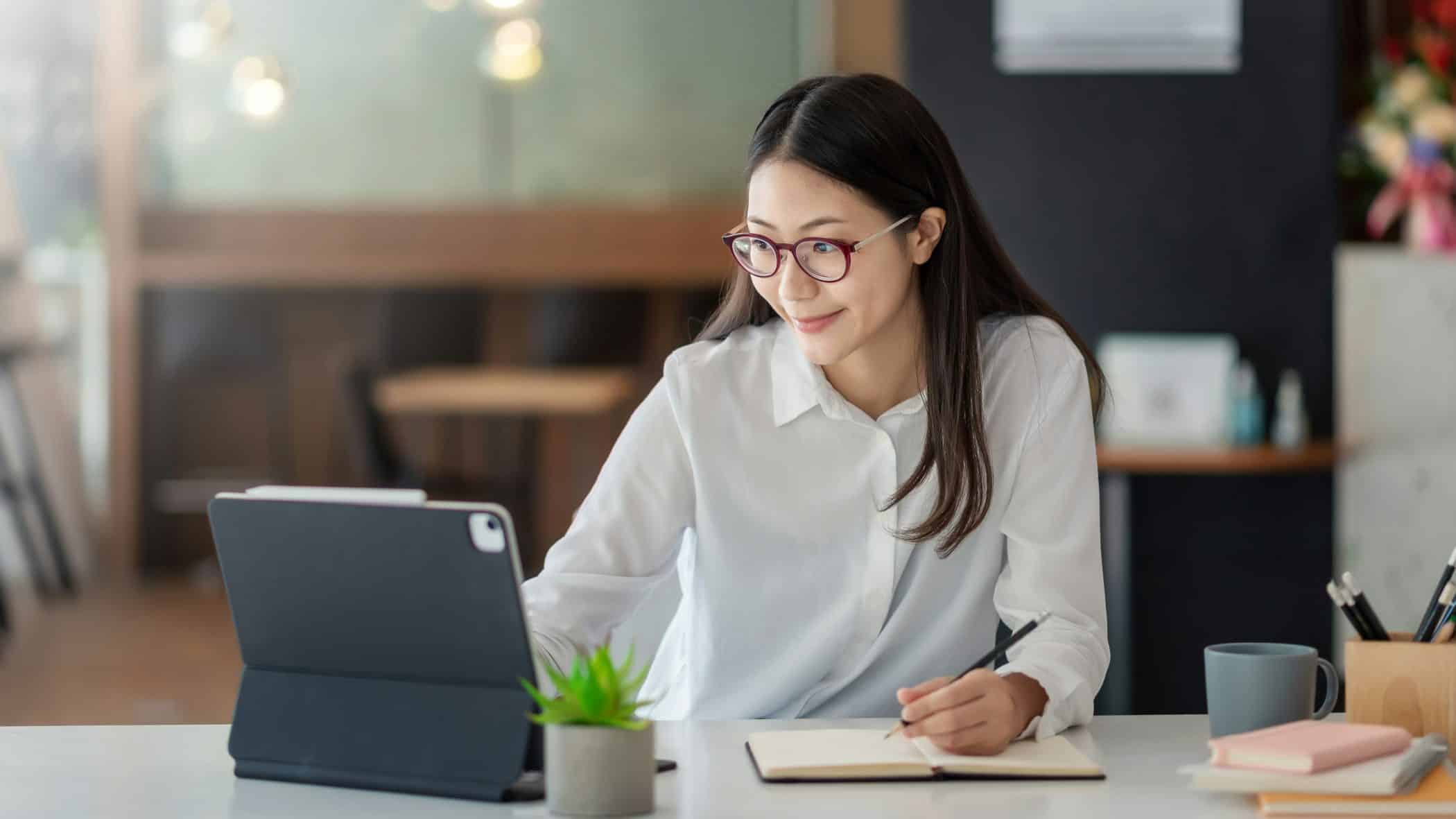 Woman in front of a tablet attending a webinar.