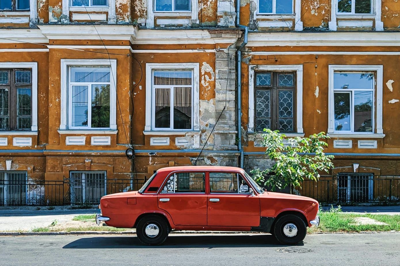 Parked red Sedan in front of residential building in Chisinau, Moldova