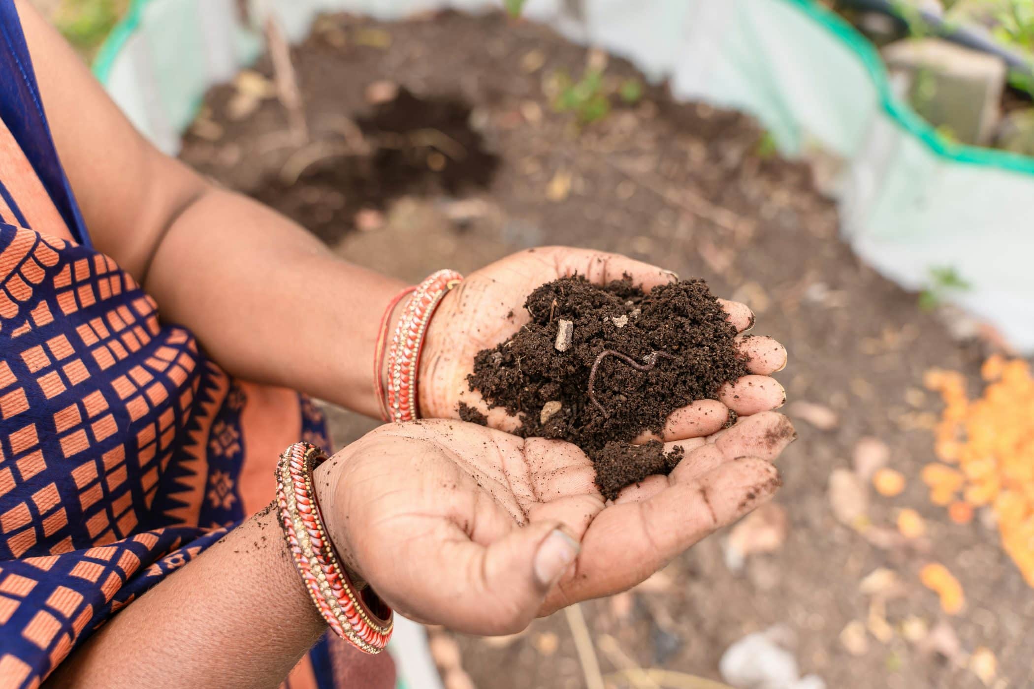 A woman holding a handful of dirt in her hands