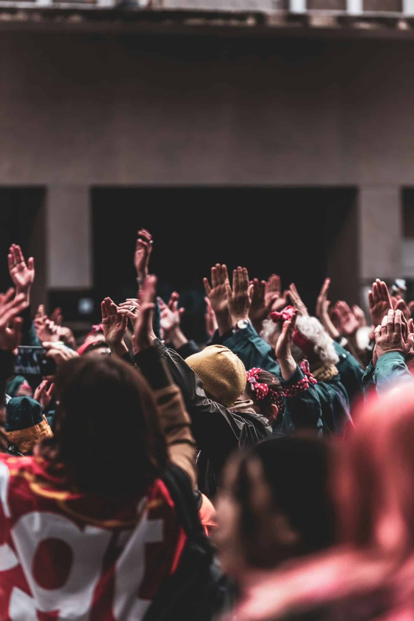 A large group of people with their hands in the air