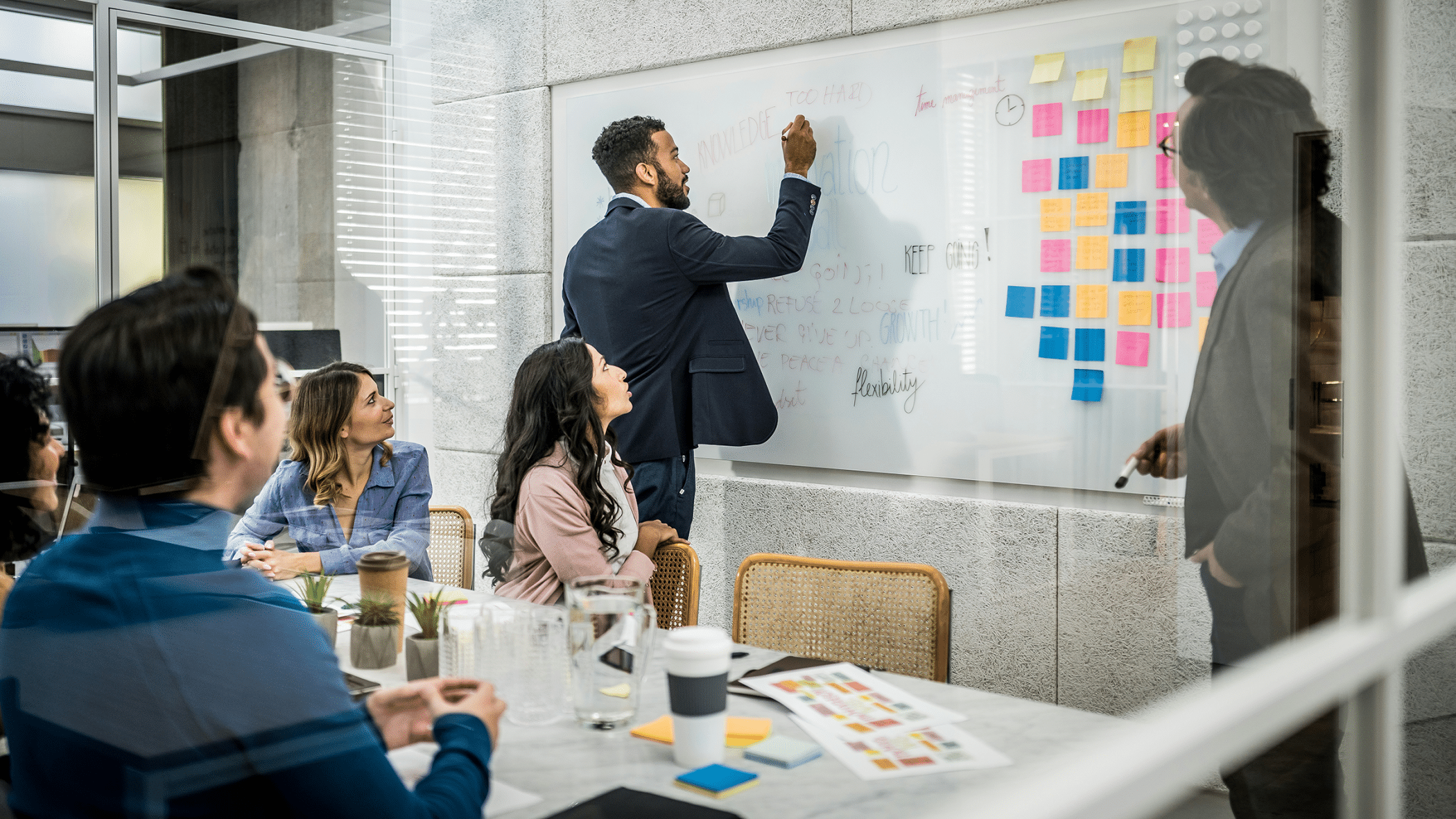 Person writing on a whitebpard during a business meeting