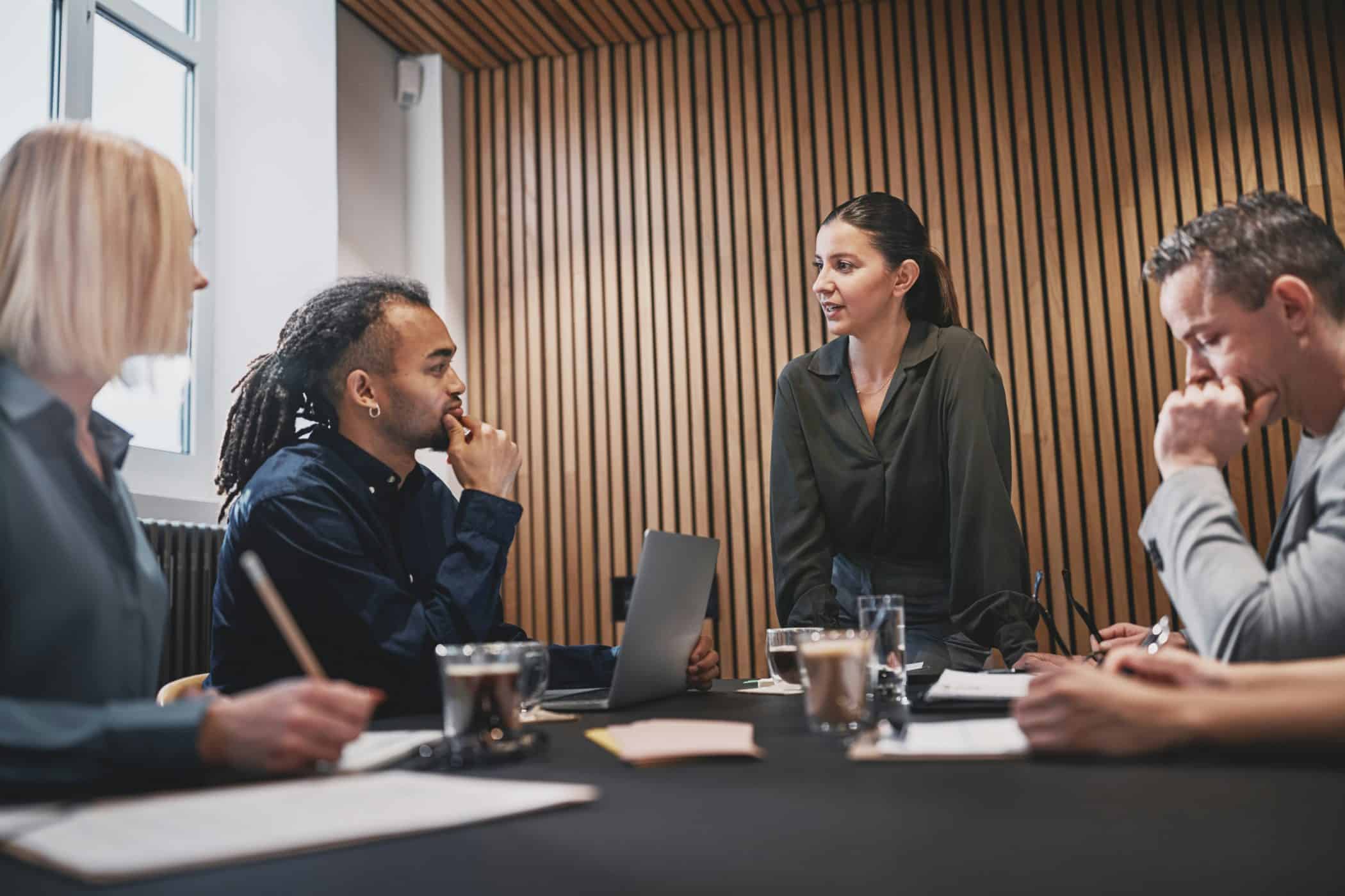 Woman talking with others during a meeting together around an office table